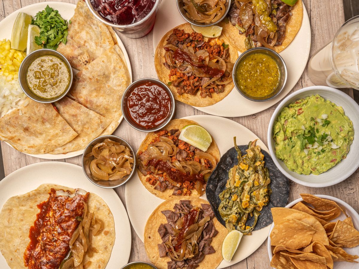 Tacos and other Mexican dishes laid out on a table.