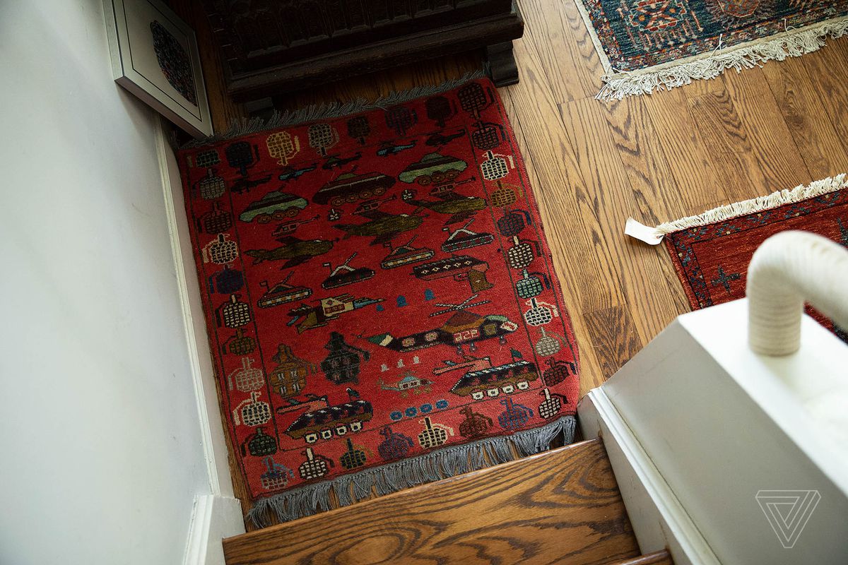 A red rug featuring an outer ring of grenades with tanks, helicopters, jets, and more on the interior.
