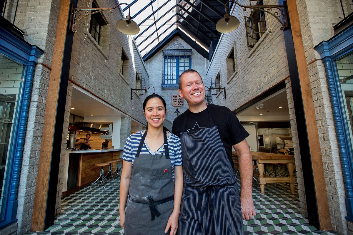 Republique’s Walter and Margarita Manzke pose in denim aprons in front of their soaring atrium dining room.
