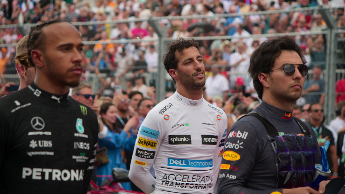 Lewis Hamilton, Danny Ricciardo, and Sergio Perez stand on the track while a national anthem plays in Drive to Survive.