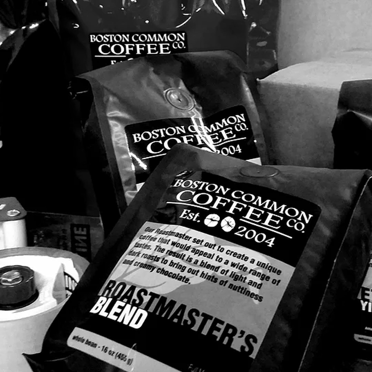 Black and white photo of several bags of coffee from Boston Common Coffee Company