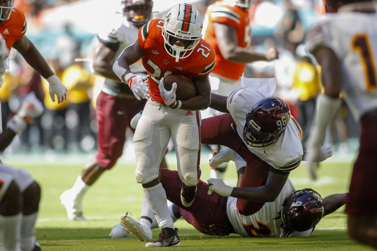Miami Hurricanes running back Henry Parrish Jr. (21) runs with the football ahead of Bethune Cookman Wildcats defensive tackle Mason Hall (96) during the second quarter at Hard Rock Stadium
