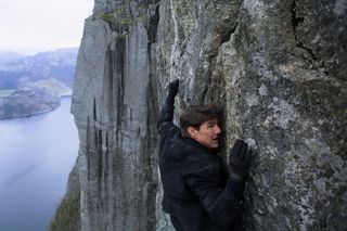 Tom Cruise hangs from a cliff in Mission: Impossible — Fallout.