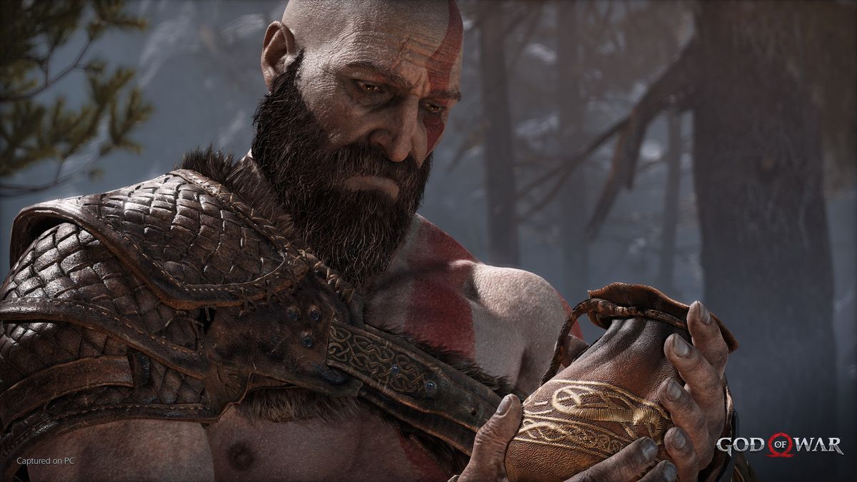 Kratos sostiene una pequeña cartera que contiene las cenizas de la madre de Atreus.  Él los mira solemnemente mientras los sostiene suavemente.