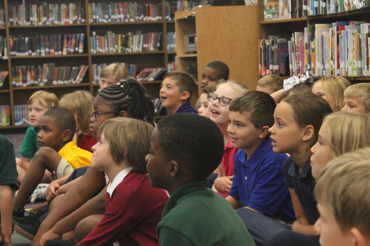 Second grade students listened attentively as Ferebee read a children’s book in the school library.