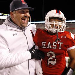 East's Jaylen Warren (2) celebrates with a coach after scoring a touchdown in the second half of the 4A high school football championships against Timpview at Rice Eccles Stadium in Salt Lake City, Friday, Nov. 20, 2015.