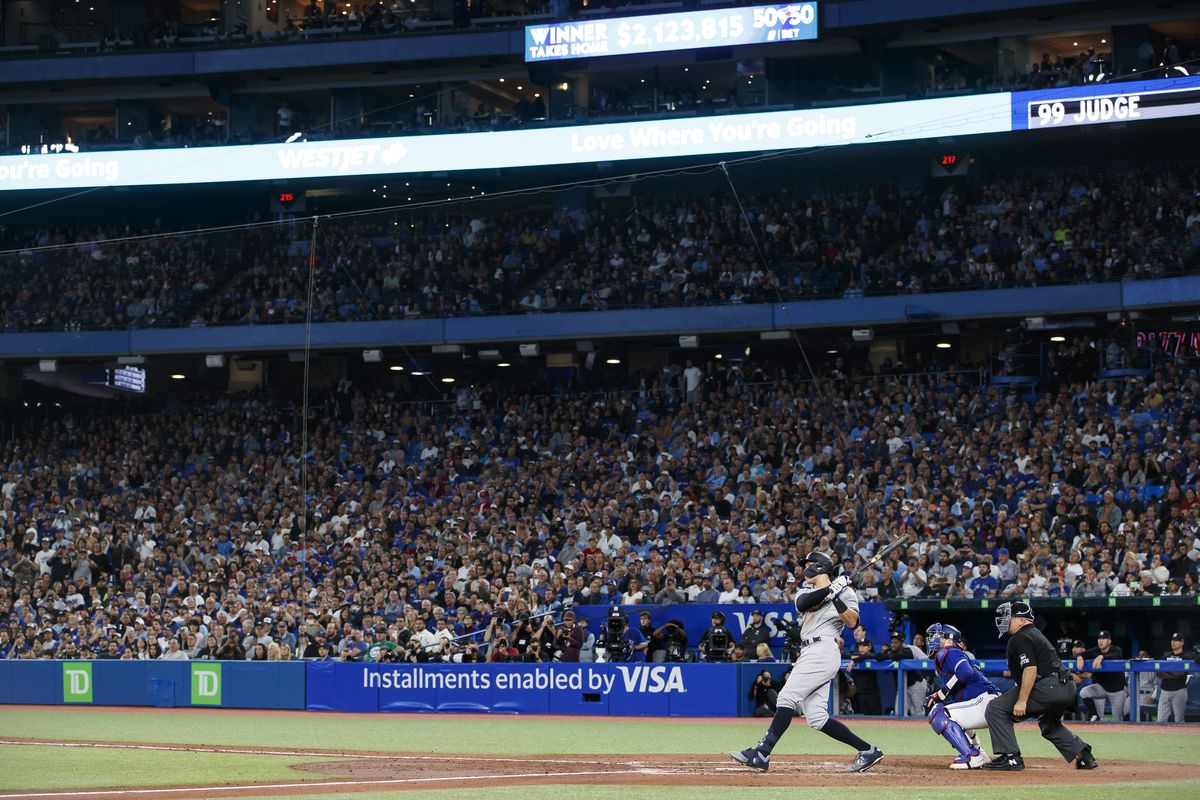 Aaron Judge #99 of the New York Yankees hits his 61st home run of the season in the seventh inning against the Toronto Blue Jays at Rogers Centre on September 28, 2022 in Toronto, Ontario, Canada.
