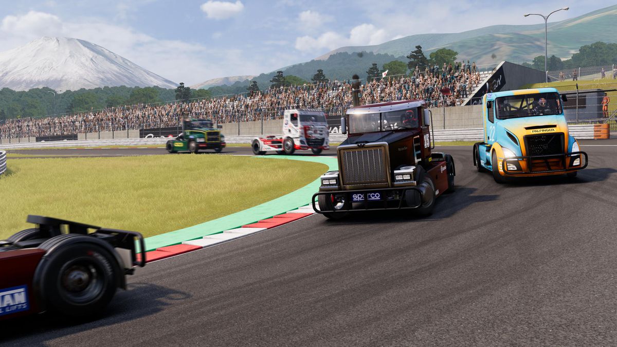 Racing trucks rounding a corner in front of a cheering crowd in FIA European Truck Racing Championship.