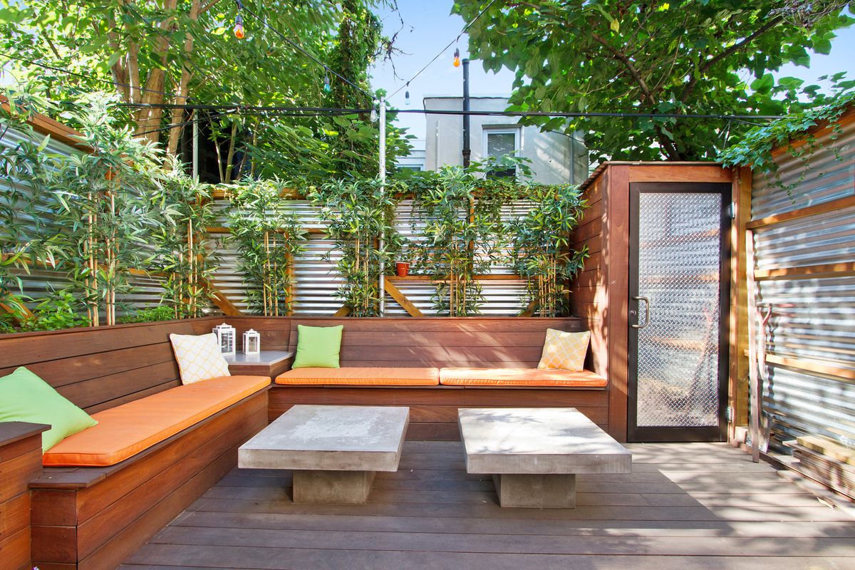 A landscaped backyard in Philadelphia with corrugated metal fences and built-in benches. 