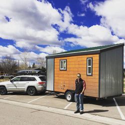 Ivor Berry stands next to his tiny house, named Tad Cooper.