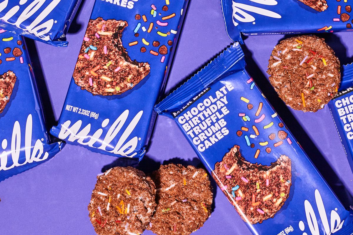 An overhead photograph of packaged cookies with bright blue branding and unpackaged cookies resting beside them