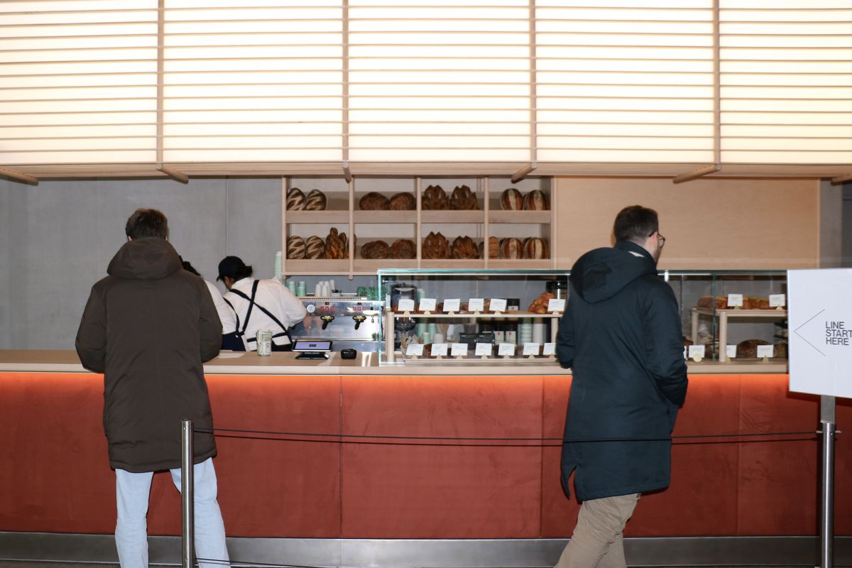 Two customers stand at the counter of a bakery in the Whitney Museum of American Art.