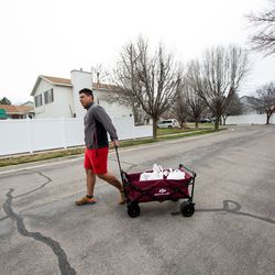 Elin Estrada walks away with a few donated items from the Utah Food Bank in Taylorsville on Monday, March 16, 2020. Hundreds of people waited in line at the parking lot of a chapel belonging to The Church of Jesus Christ of Latter-day Saints to receive the donations.