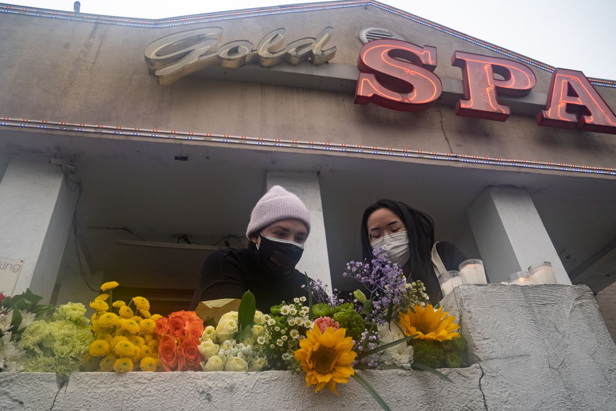 Mourners visit and leave flowers at the site of two shootings at spas across the street from one another, in memorial for the lives lost, on March 17, 2021 in Atlanta, Ga.
