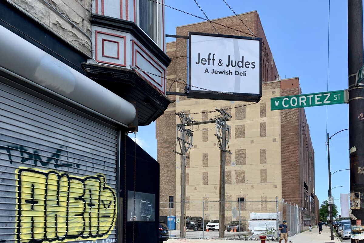 A corner space with a large white sign that reads “Jeff &amp; Judes, A Jewish Deli.”