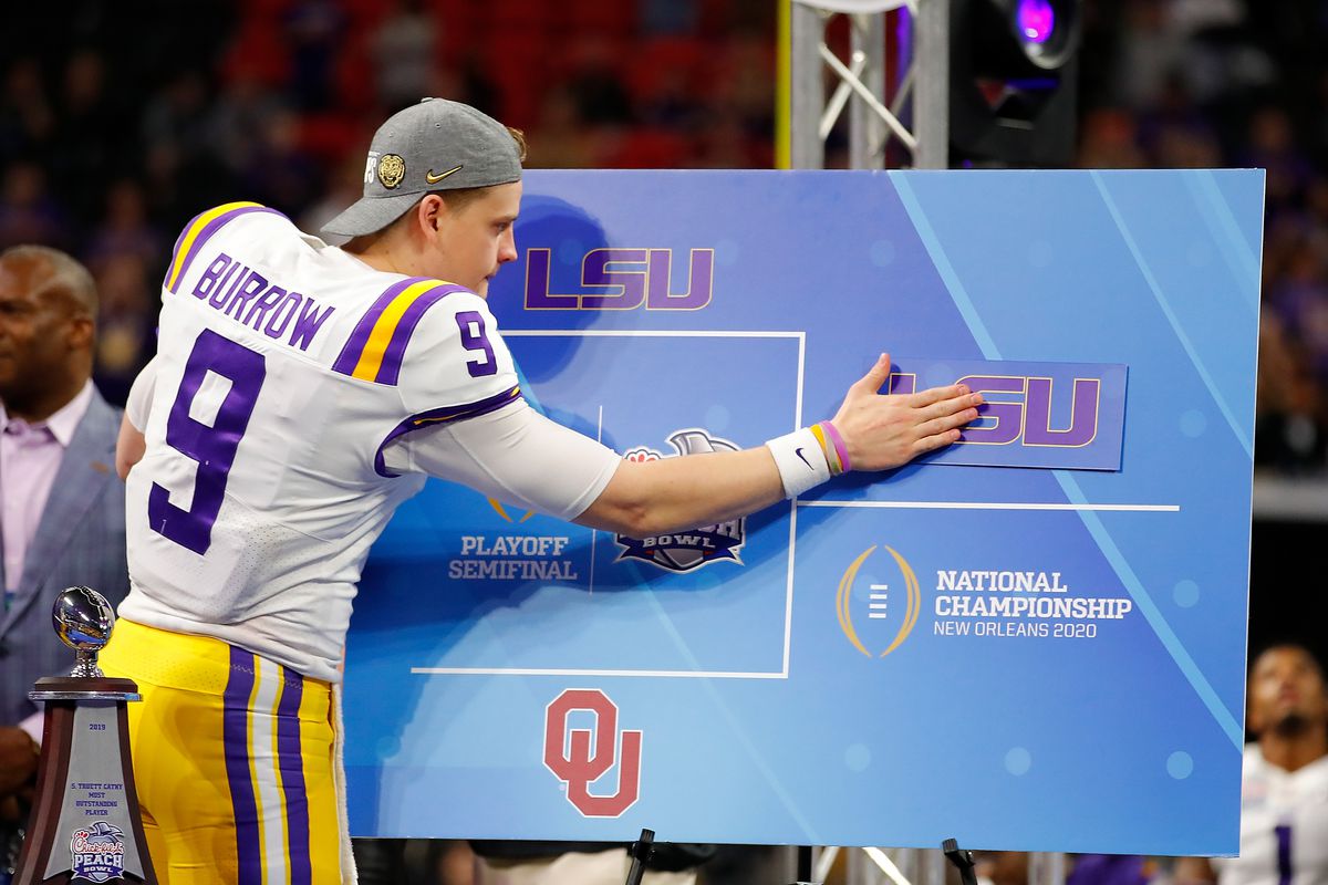 Quarterback Joe Burrow of the LSU Tigers post the “LSU” sticker on the oversized bracket to indicate advancing to the National Championship in New Orleans after winning the Chick-fil-A Peach Bowl 28-63 over the Oklahoma Sooners at Mercedes-Benz Stadium on December 28, 2019 in Atlanta, Georgia.