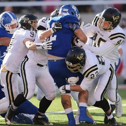 Bingham's Amoni Kaili is gang tackled by the Lone Peak defense in the 5A state championship high school football game in Salt Lake City on Friday, Nov. 18, 2016.