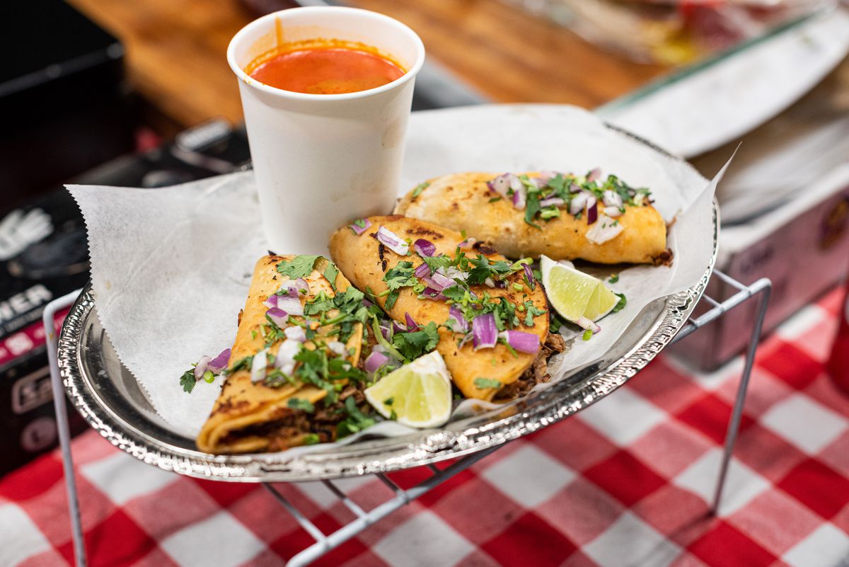 Crispy birria tacos at the ready, with consomme in a cup.