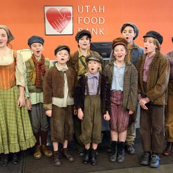 Cast members from Pioneer Theatre Company's “Oliver!” sing “Consider Yourself,” a song from the musical, before sorting food donations at the Utah Food Bank in Salt Lake City on Monday, Dec. 5, 2016.