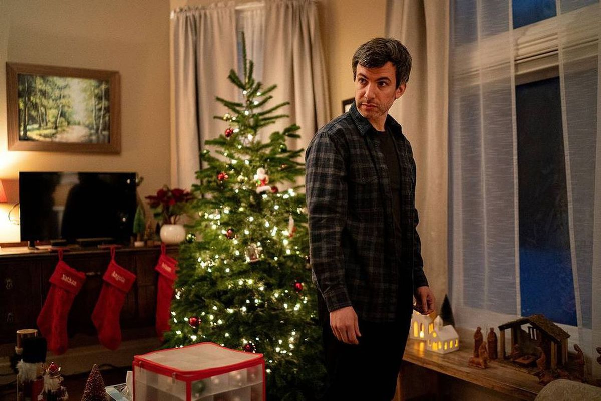 Nathan Fielder stands in front of a Christmas tree.