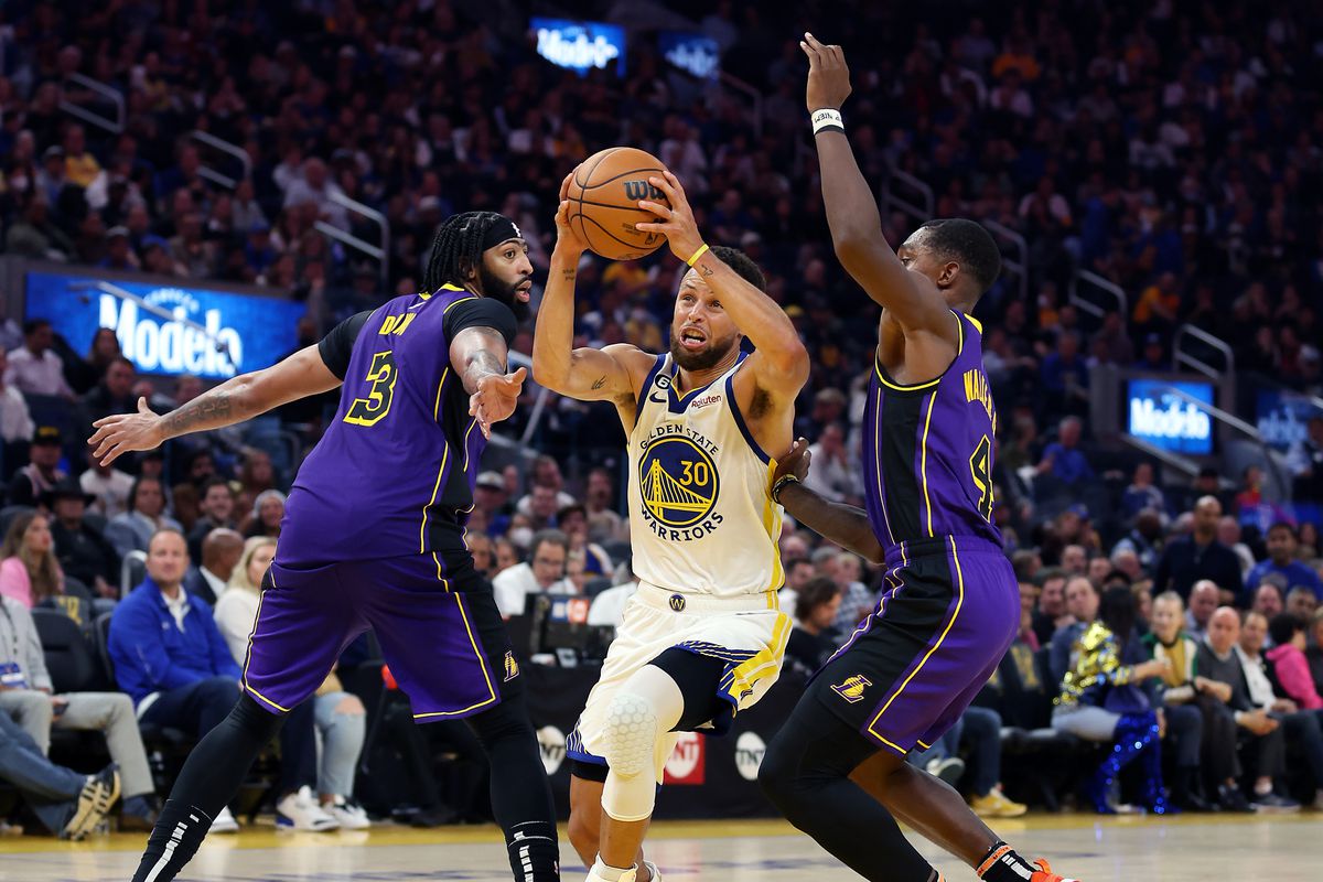 Steph Curry #30 of the Golden State Warriors drives toward the basket as Lonnie Walker IV #4 and Anthony Davis #3 of the Los Angeles Lakers