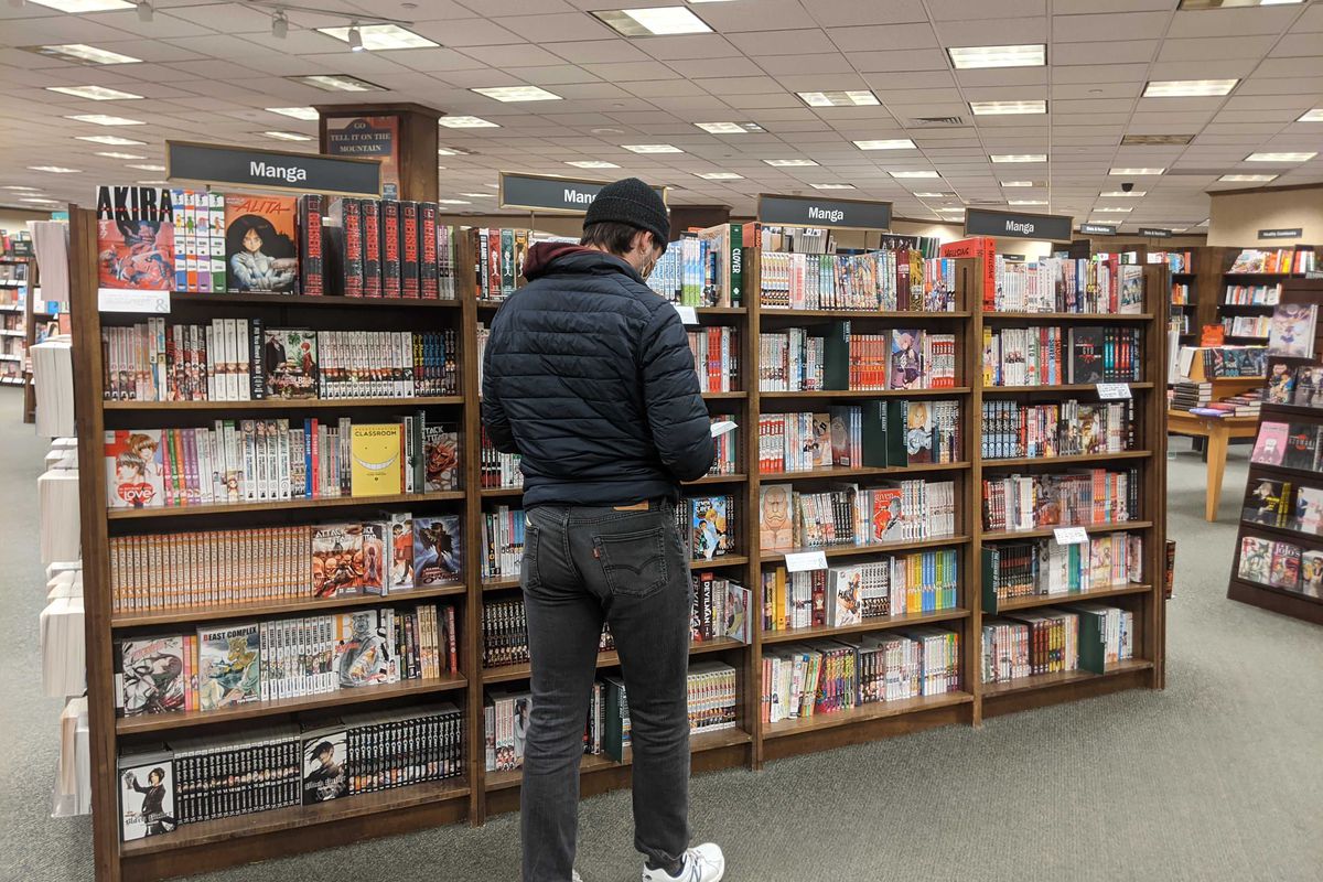 A young man standing browsing some manga in the manga section of Barnes and Noble