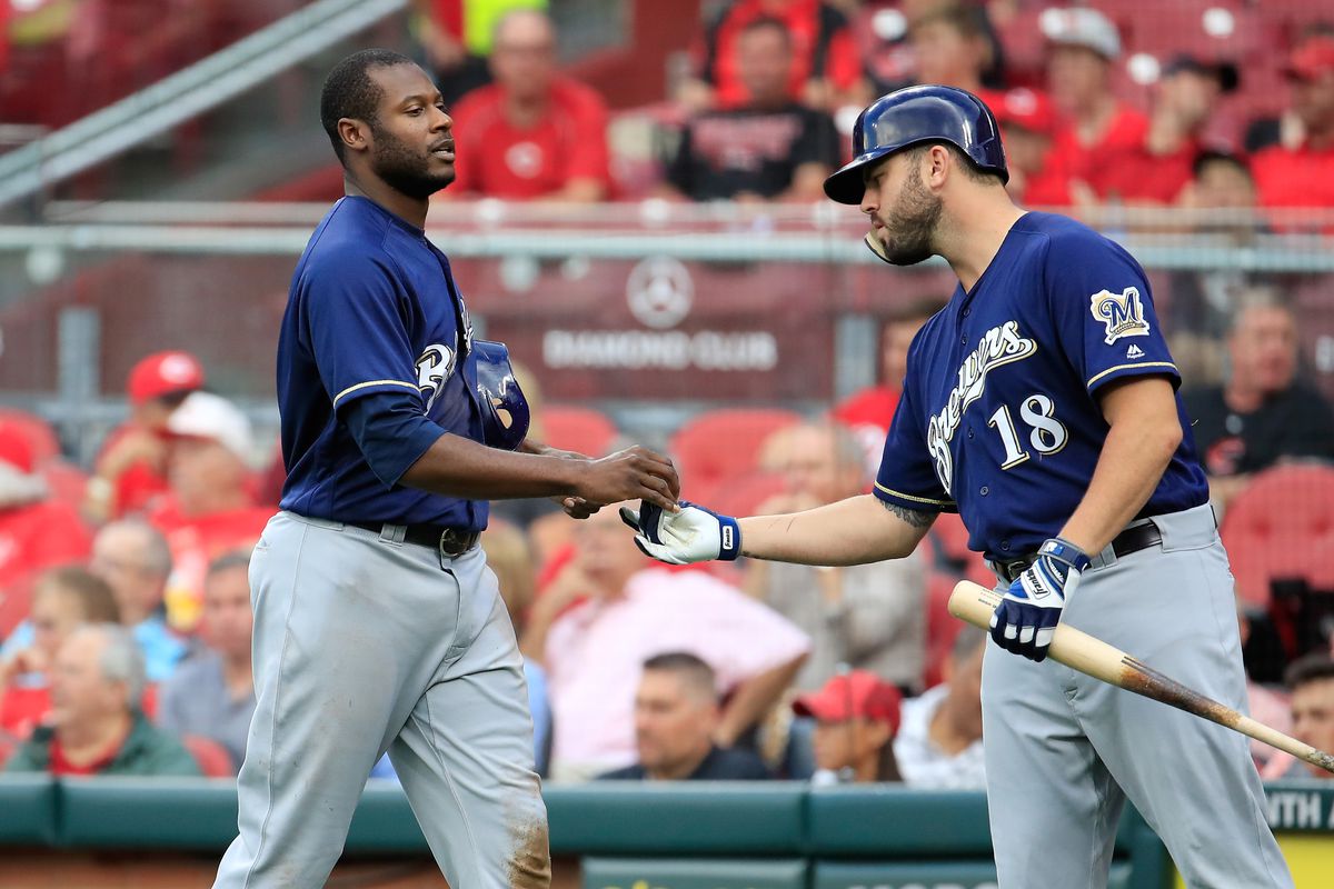 Lorenzo Cain #6 of the Milwaukee Brewers is congratulated by Mike Moustakas #18 after scoring in the first inning against the Cincinnati Reds at Great American Ball Park on August 29, 2018 in Cincinnati, Ohio.