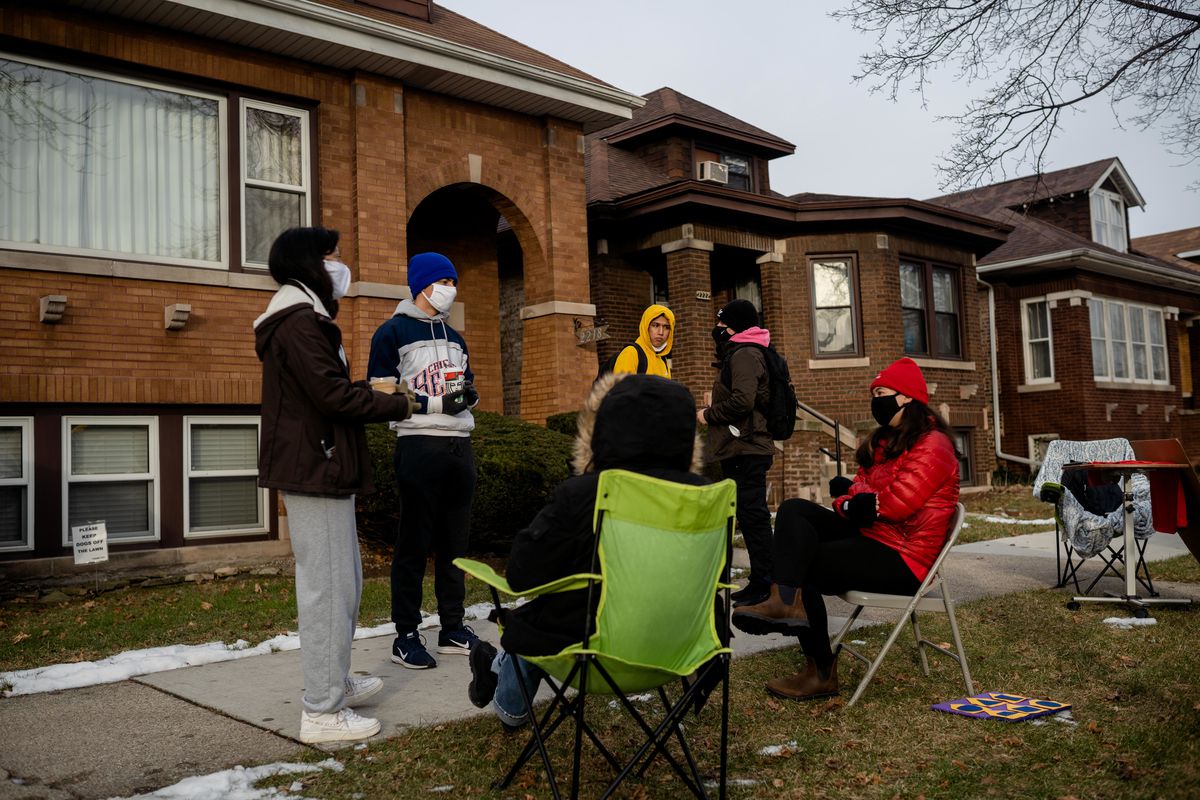 Chicago Public Schools alums Genesis Rivera (left) and Diego Garcia (blue hat) stand with teachers Wednesday morning outside the Belmont Cragin home of Miguel del Valle, president of the Chicago Public Schools board, on Wednesday, Jan. 13, 2021.