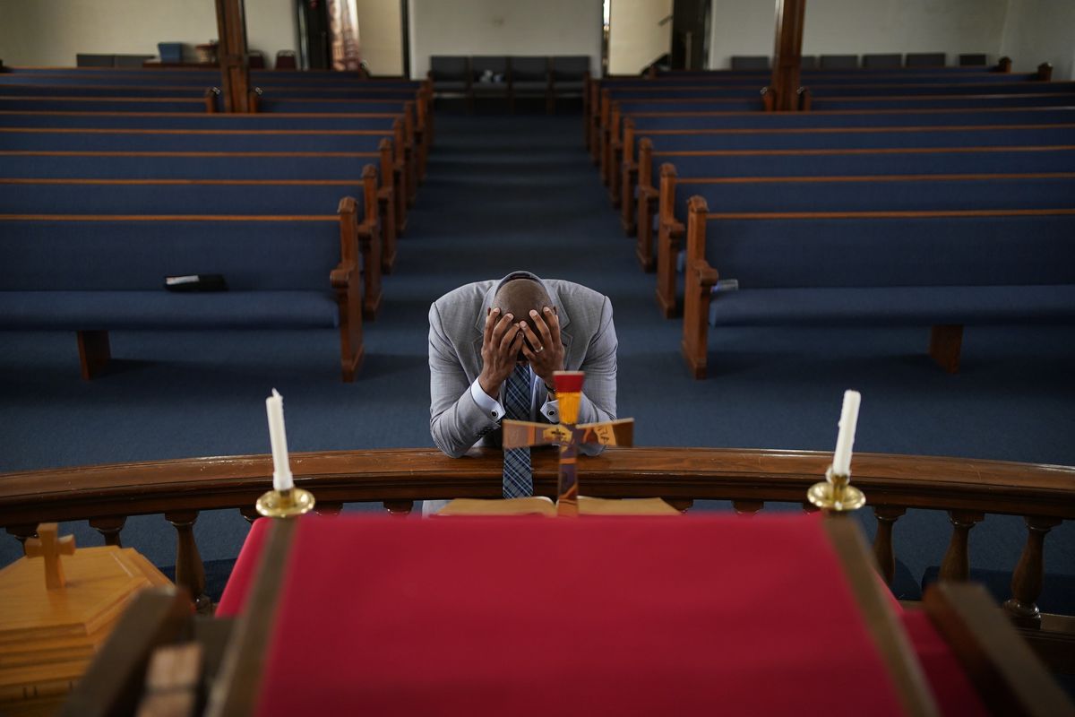 In this May 28, 2021, photo, Rev. Robert R.A. Turner, pastor of the historic Vernon African Methodist Episcopal Church, prays in the sanctuary of the church between meetings around centennial commemorations of the Tulsa Race Massacre in Tulsa, Okla.