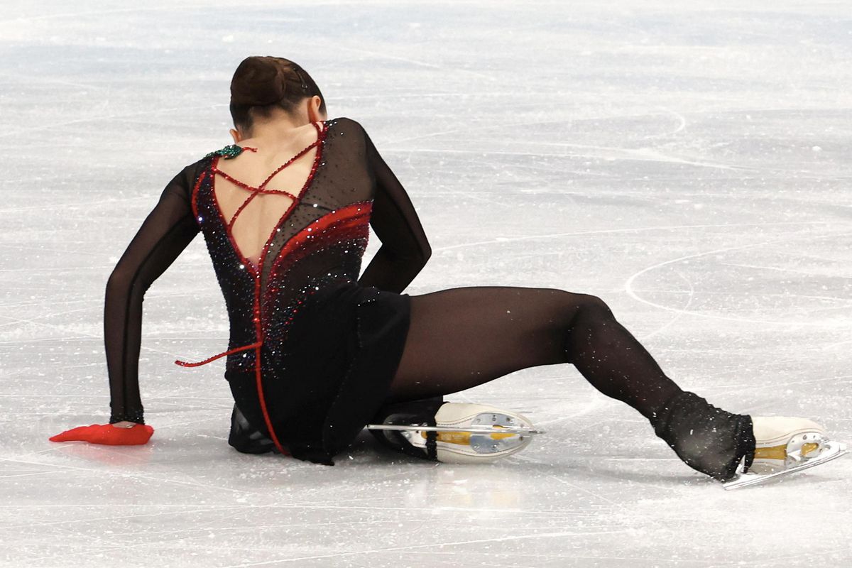 A figure skater getting up from a fall on the ice.