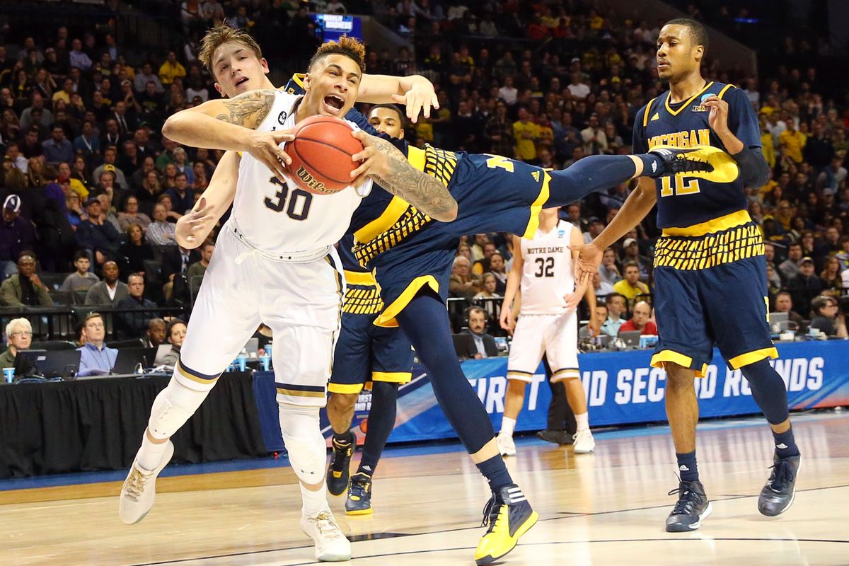 Zach Auguste is tackled by Michigan's Mark Donnal.