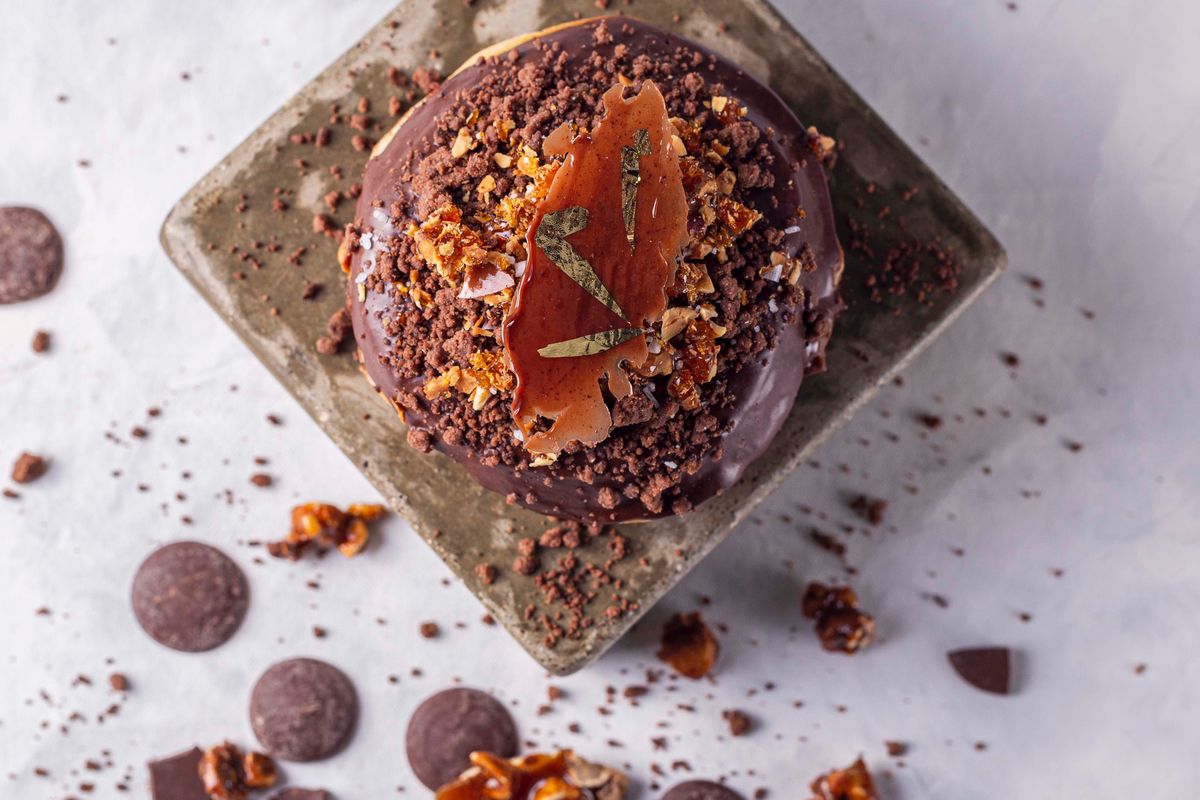 A chocolate doughnut with gold leaf flakes