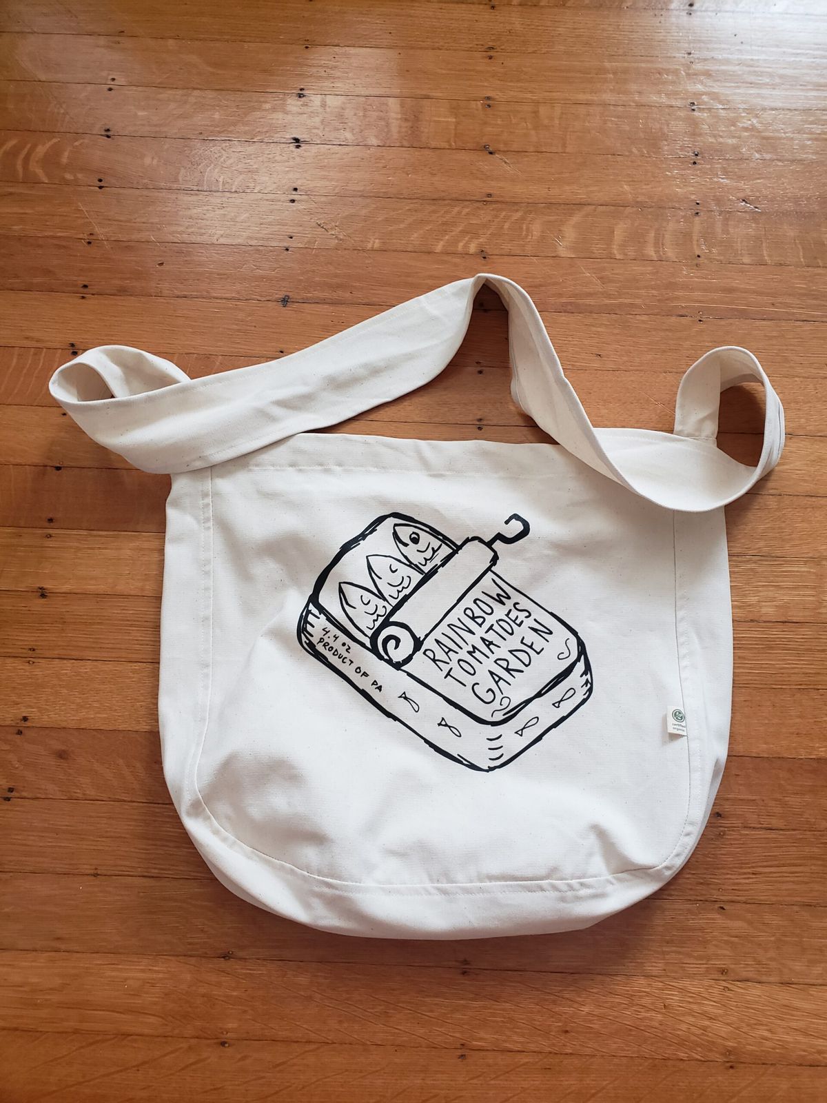 A white tote bag with black ink illustrations. 