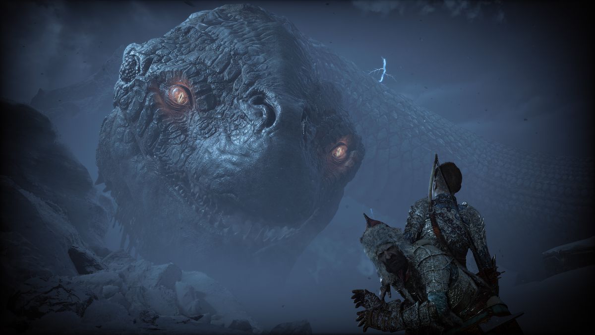 Atreus looks up at the towering World Serpent, Jörmungandr, while Sindri cowers behind him in God of War Ragnarök