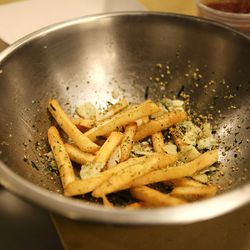 Tossing fries with truffle oil and funkaki (Japanese rice seasoning).