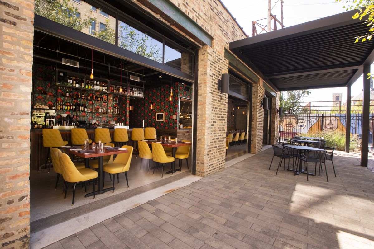 A restaurant dining room opens directly onto a brick outdoor patio.