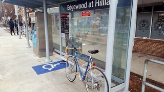 Una bicicletta blu si appoggia ai sedili della piattaforma del tram.