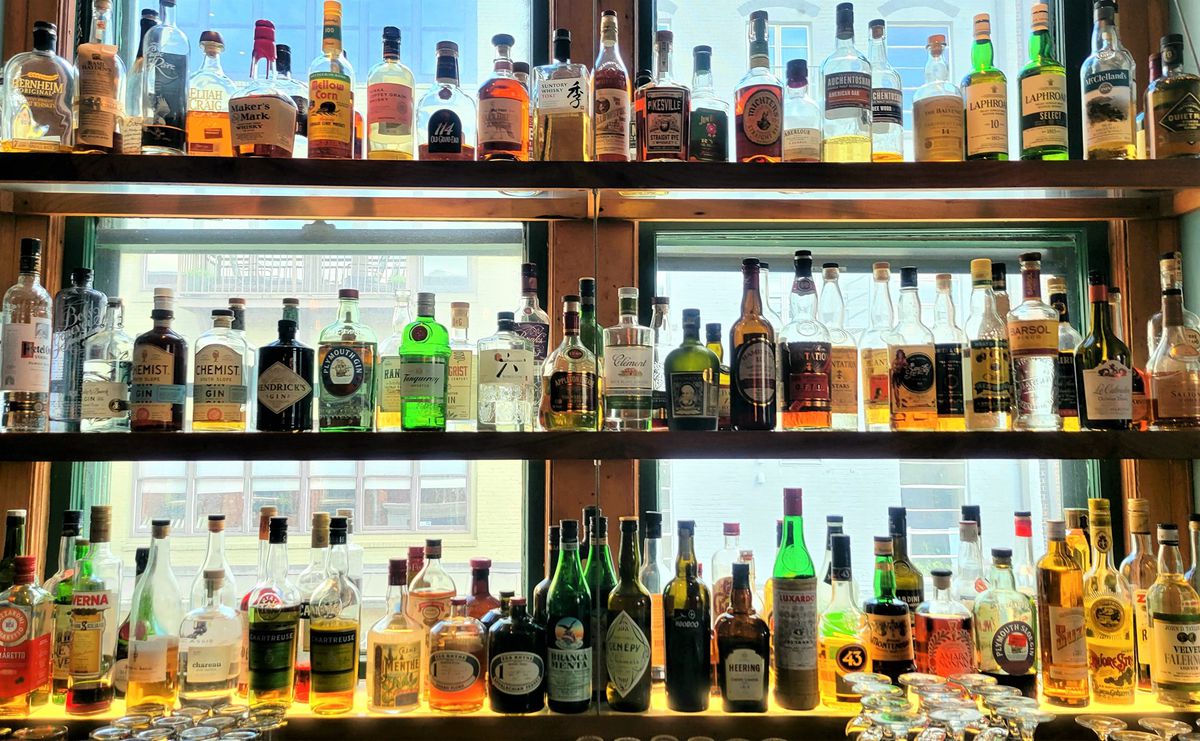 Bottles on three shelves of glass.