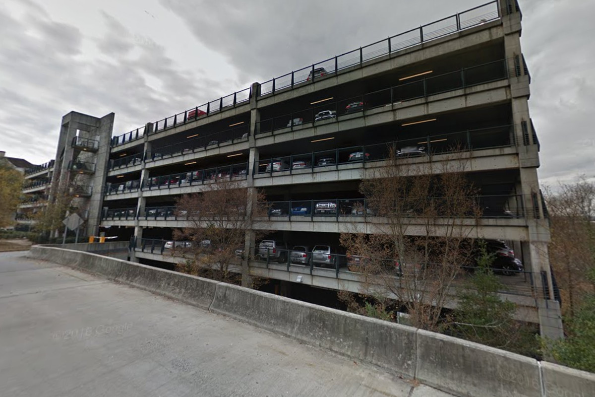A large parking deck is filled with cars.