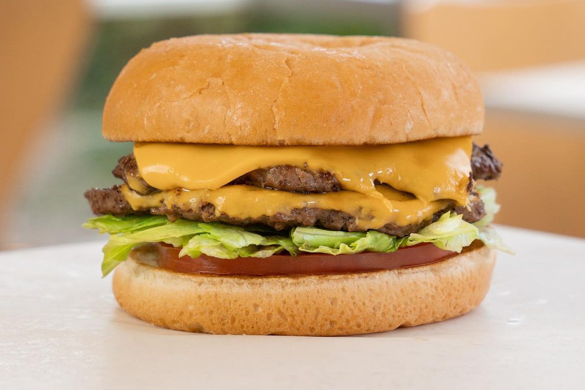 A double-patty cheeseburger with lettuce and tomato.