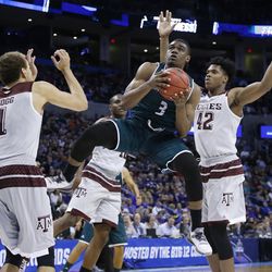 Green Bay guard Khalil Small (3) drives to the basket between Texas A&M forward D. J.  Hogg (1) and forward Tavario Miller (42) in the second half of a first-round men's college basketball game in the NCAA Tournament, Friday, March 18, 2016, in Oklahoma City. (AP Photo/Sue Ogrocki) 