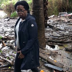 This Wednesday, Jan. 10, 2018, photo provided by Oprah Winfrey shows Winfrey standing in debris and mud flow as she looks at her neighbors property in Montecito, Calif. As search dogs clambered on heaps of wood that used to be homes, mud-spattered rescue teams from all over California worked their way through the ruins of Montecito, an enclave of 9,000 people northwest of Los Angeles that is home to celebrities. (Oprah Winfrey via AP)