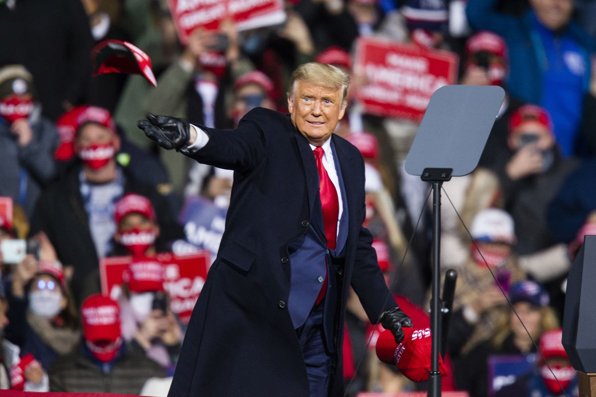 President Donald Trump throws MAGA caps to supporters as he arrives to speak during a rally on October 31, 2020 in Montoursville, Pennsylvania.