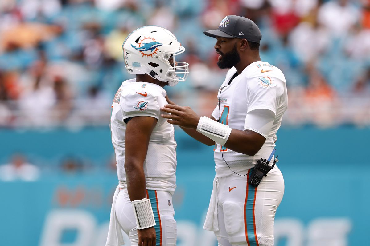 Tua Tagovailoa #1 of the Miami Dolphins talks with Jacoby Brissett #14 during the second quarter in the game against the Atlanta Falcons at Hard Rock Stadium on October 24, 2021 in Miami Gardens, Florida.