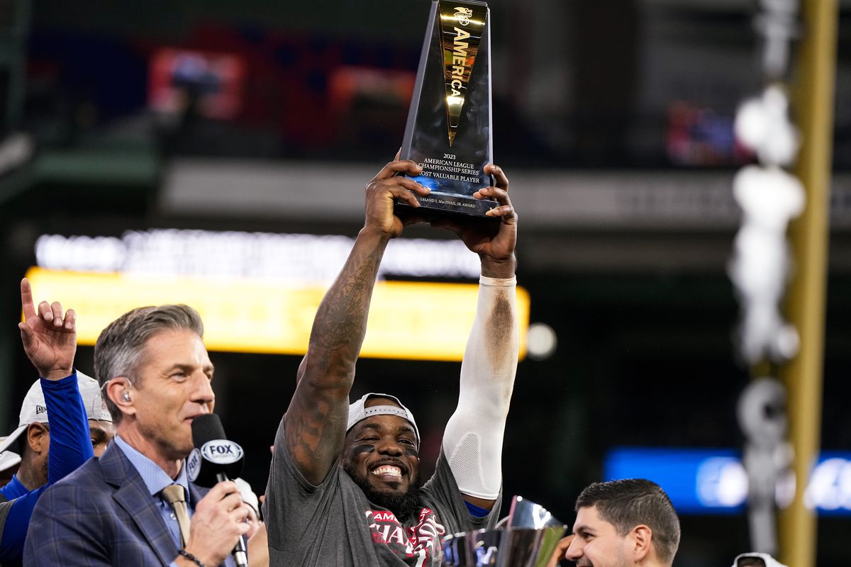 Adolis Garcia of the Texas Rangers hoists the ALCS MVP Trophy after defeating the Houston Astros in Game Seven to win the American League Championship Series at Minute Maid Park on October 23, 2023 in Houston, Texas.