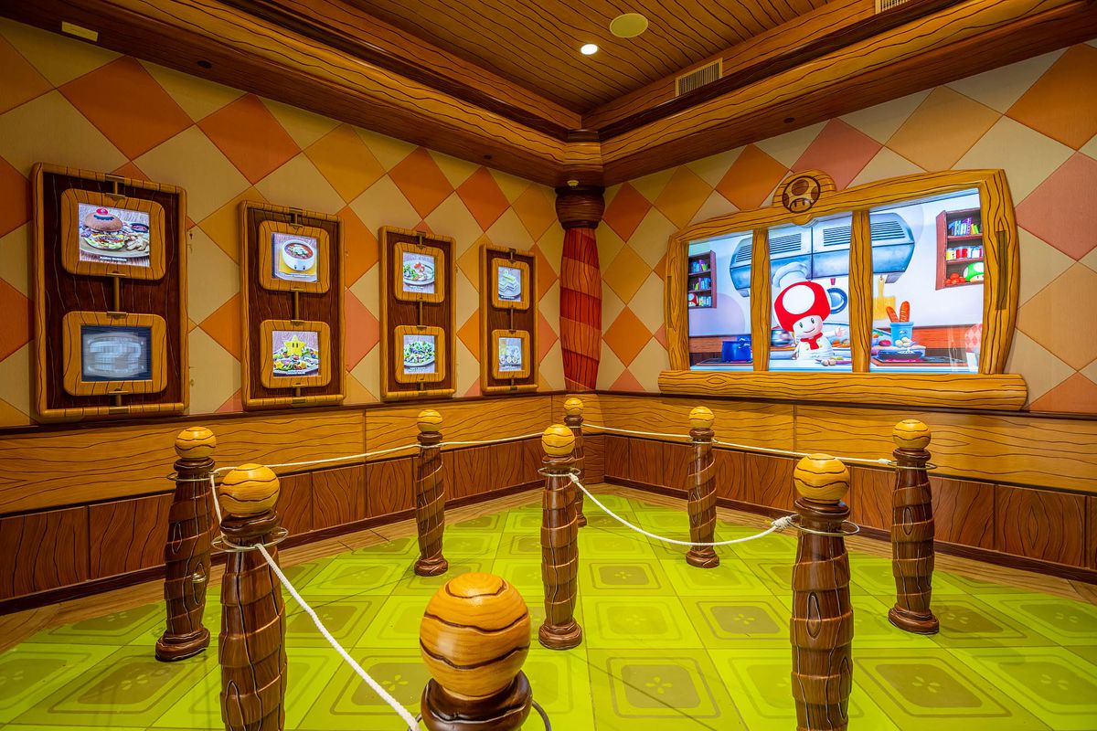 A digital rendering of “Chef Toad” prepping in a virtual kitchen greets diners at Toadstool Cafe.