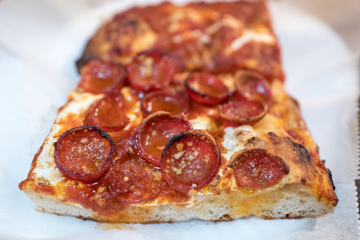 A square slice of Prince Street pepperoni pizza sits on white paper