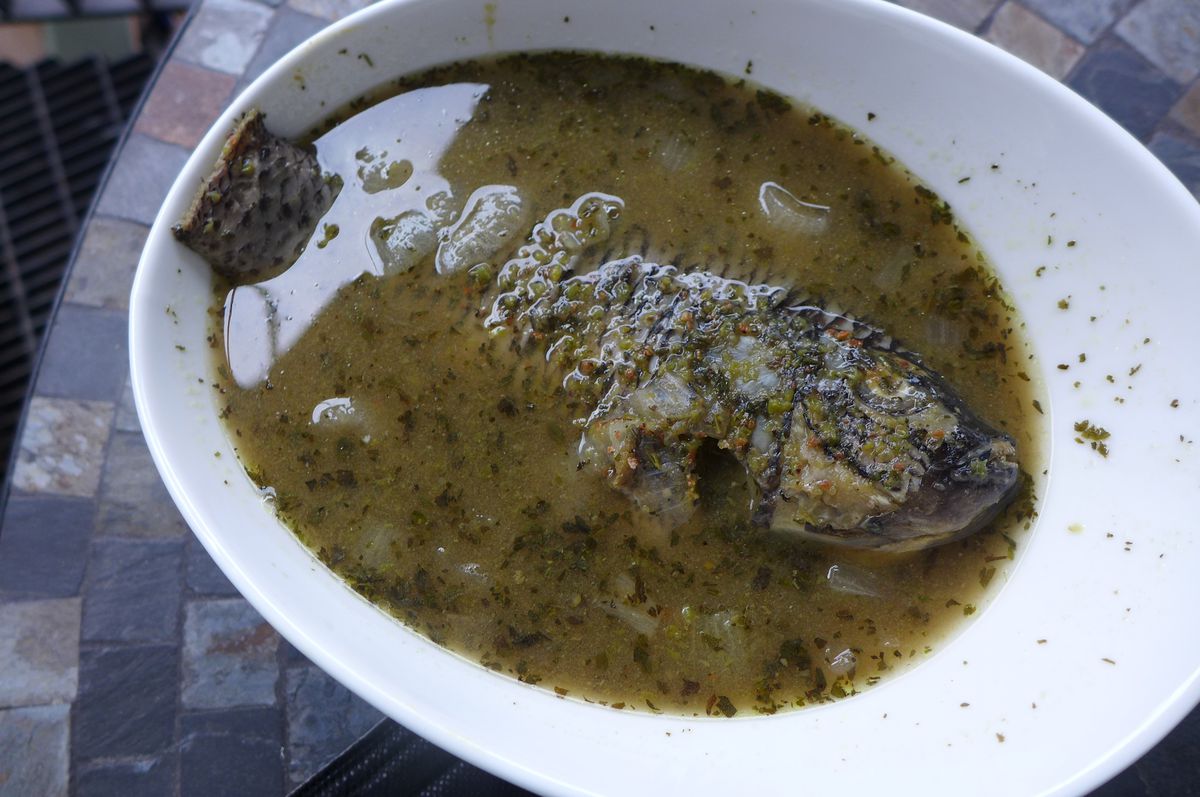 A whole fish floating in gray liquid.