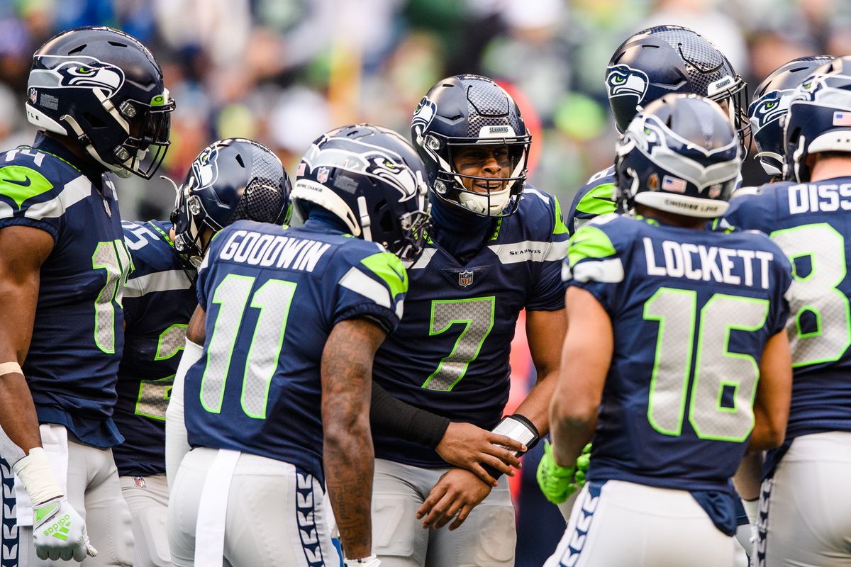 Geno Smith #7 of the Seattle Seahawks gathers his teammates during the first quarter of the game against the Carolina Panthers at Lumen Field on December 11, 2022 in Seattle, Washington.