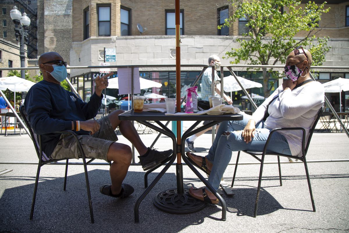 Anthony Jackson, left, and Robin Jackson, right, relax on a street patio on North Broadway, in Lakeview, Chicago, Friday June 12, 2020. North Broadway from Belmont Ave to Diversey Parkway will closed off to traffic as part of Mayor Lori Lightfoot’s “Make Way For Dining” program. Dine Out on Broadway will be in progress from noon to 10 p.m. Friday, and from 11 a.m. to 10 p.m. Saturday and Sunday.